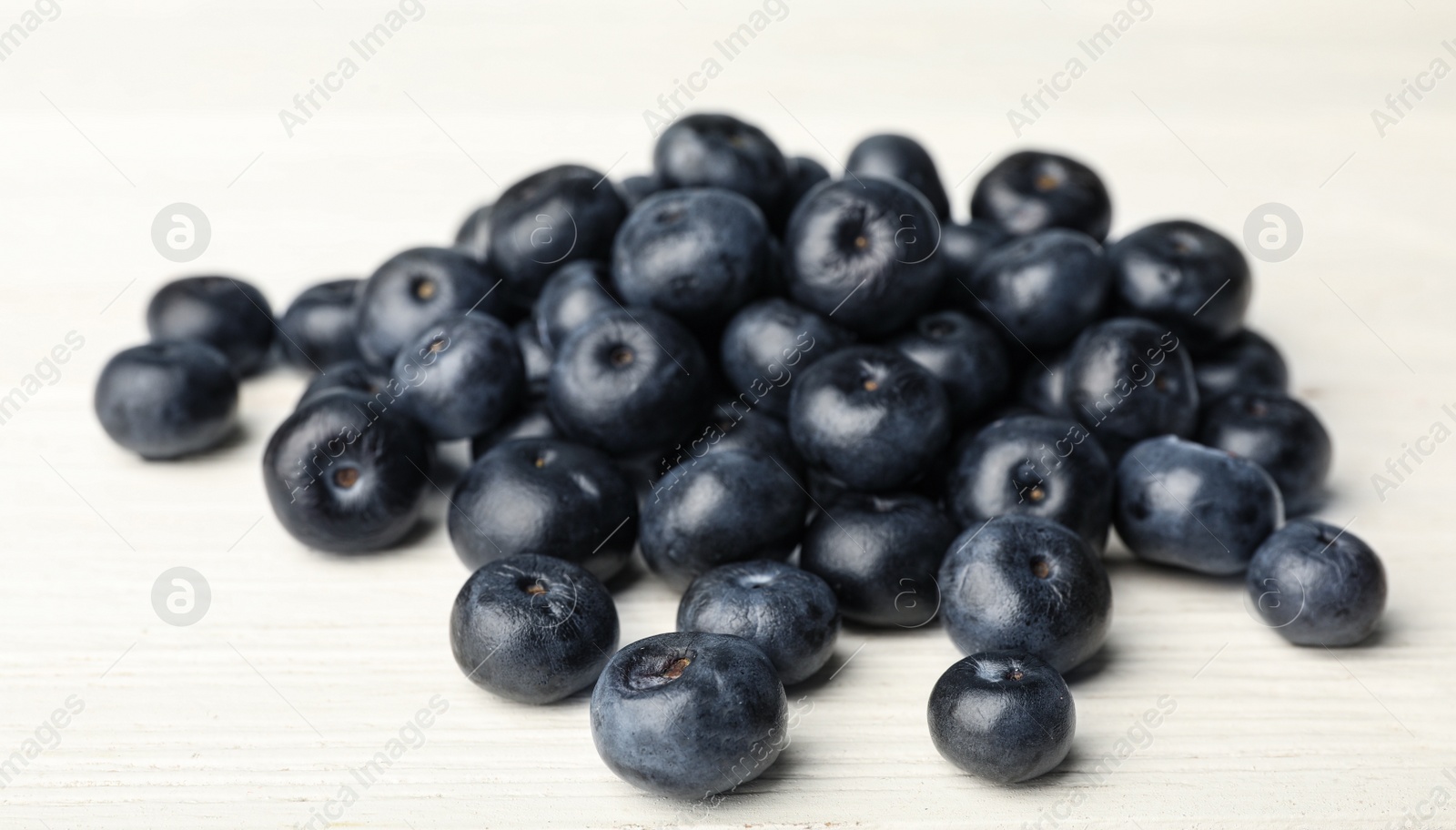 Photo of Fresh acai berries on white wooden table, closeup view