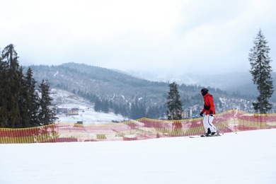Skier on slope at resort. Winter vacation