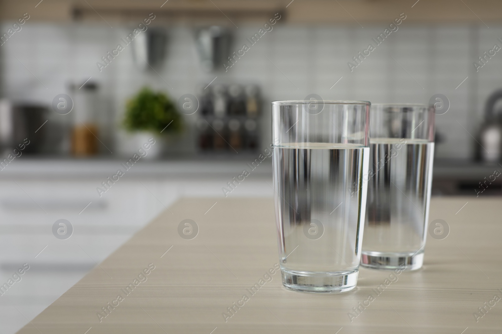 Photo of Glasses of fresh water on table indoors. Space for text