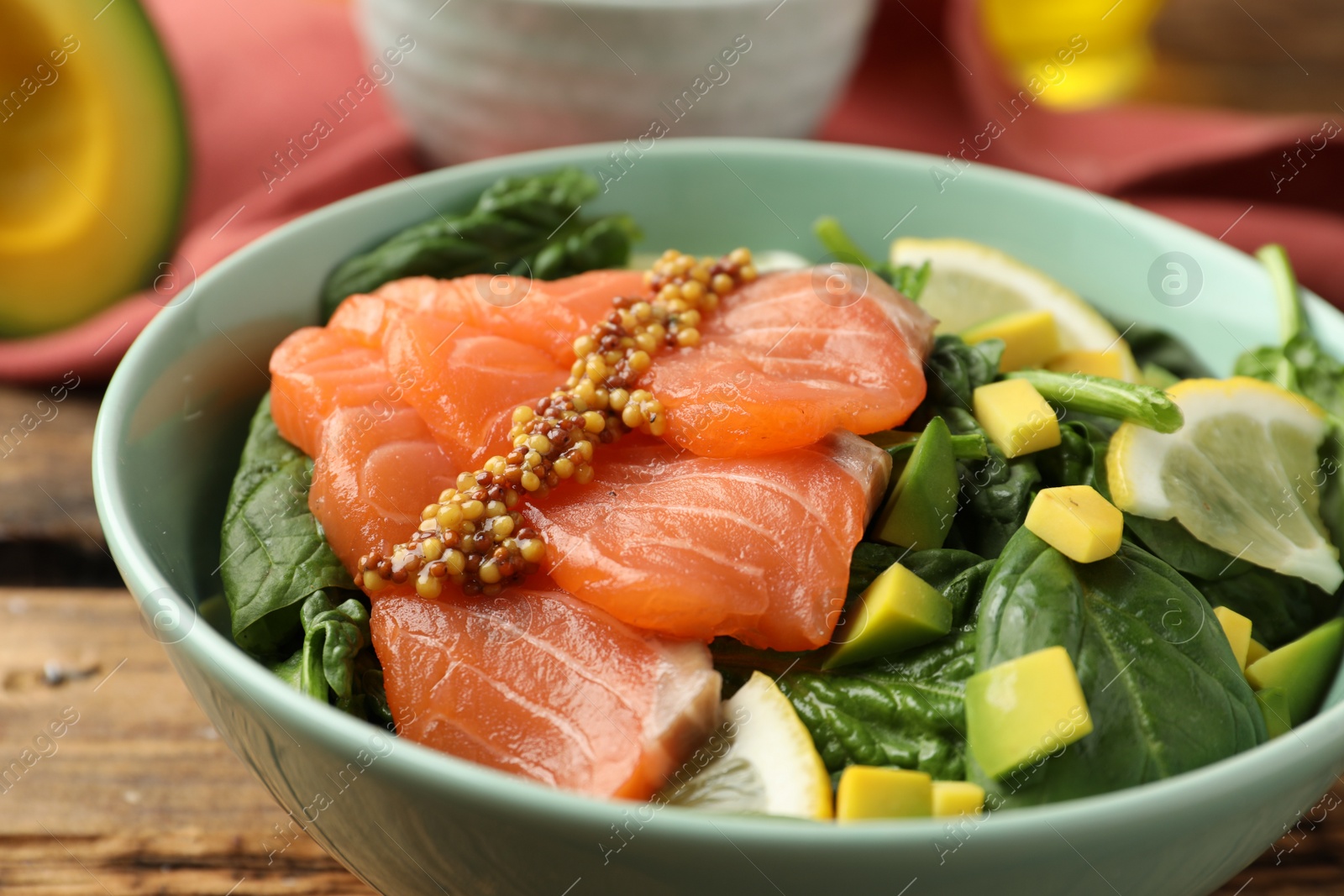 Photo of Delicious fresh salmon with spinach, avocado and lemon in bowl, closeup