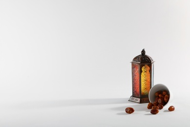Photo of Muslim lamp and dates on white background. Space for text