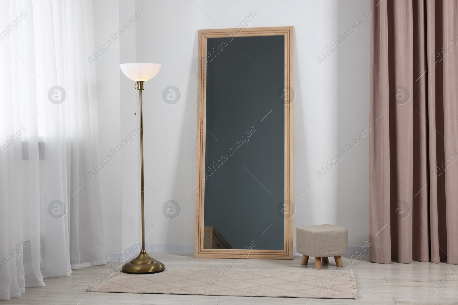 Photo of Stylish makeup room interior with long mirror and lamp