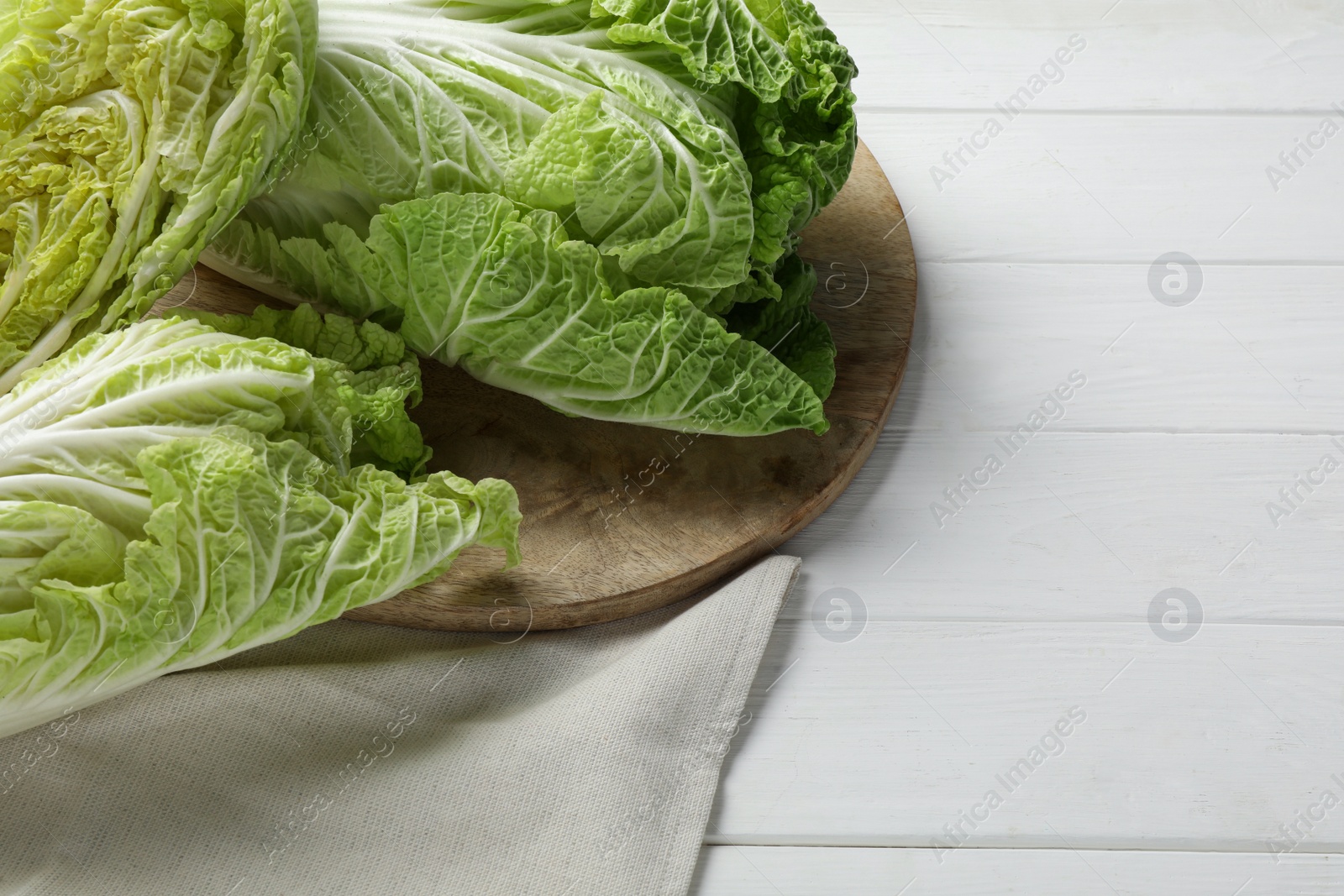 Photo of Fresh ripe Chinese cabbages on white wooden table, space for text