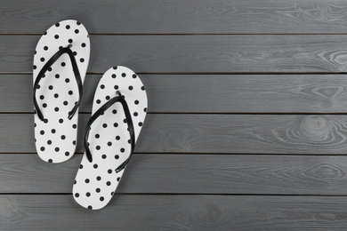 Photo of Stylish flip flops on grey wooden background, flat lay. Space for text