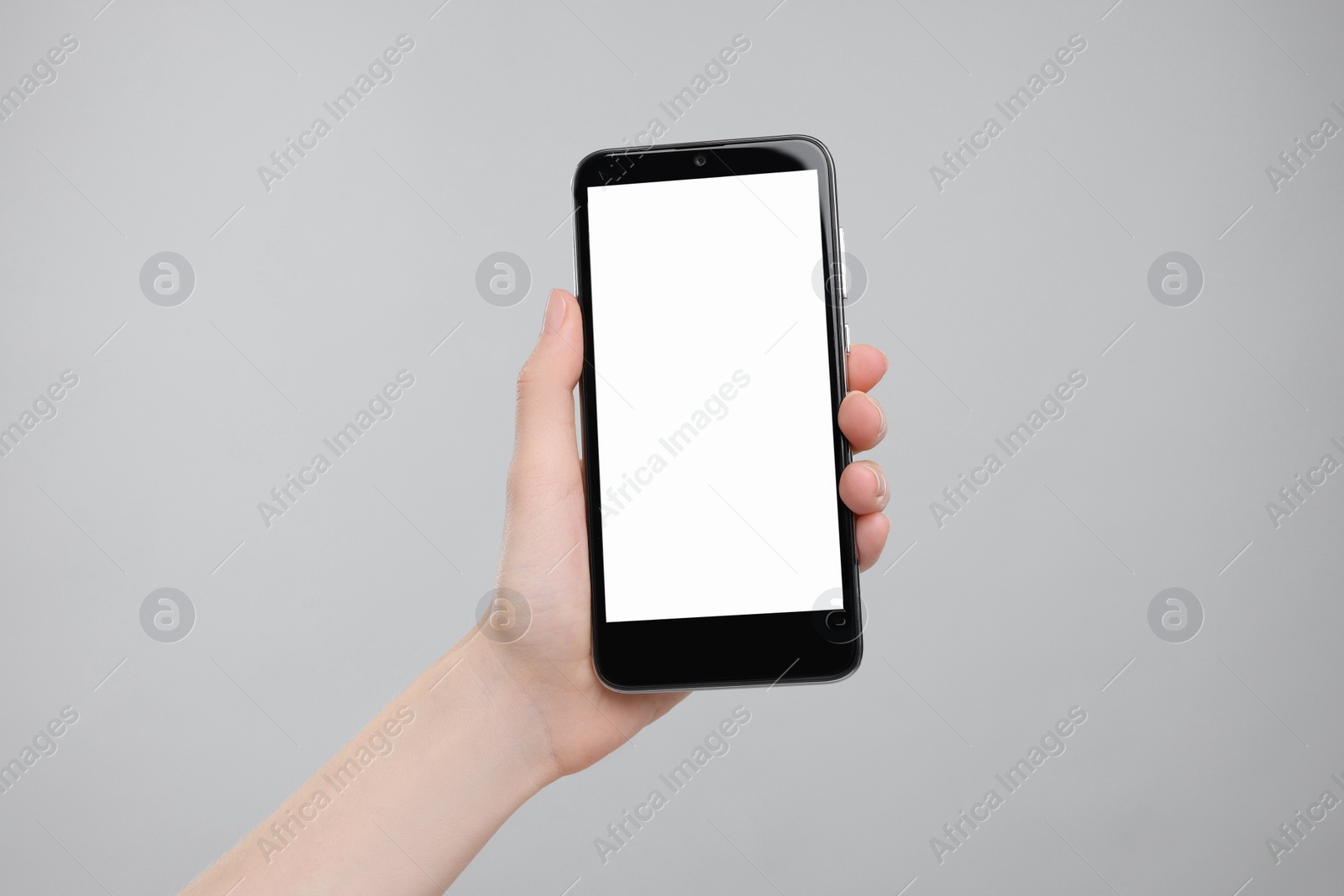 Photo of Woman holding smartphone with blank screen on grey background, closeup. Mockup for design