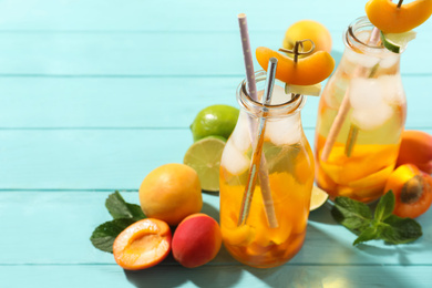 Delicious refreshing drink with apricot on light blue wooden table. Space for text