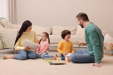 Photo of Happy family spending time together on floor in living room