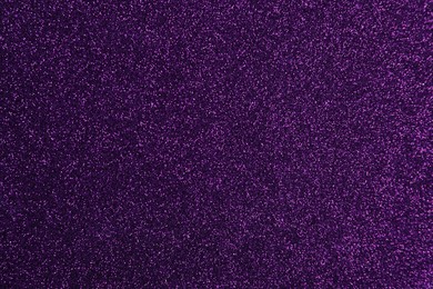 Photo of Shiny dark purple glitter as background, closeup