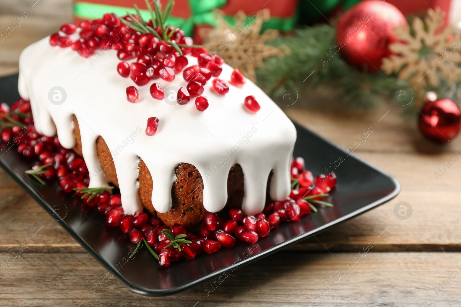 Photo of Traditional classic Christmas cake decorated with pomegranate seeds and rosemary on wooden table