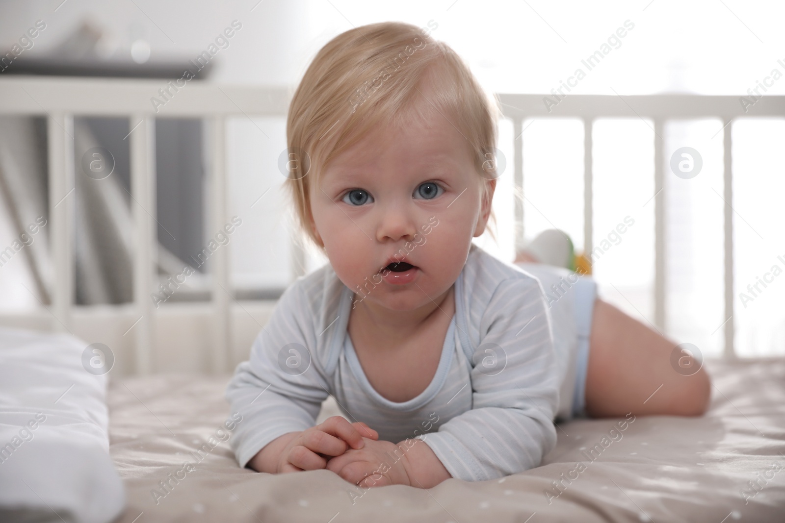 Photo of Adorable little baby lying in comfortable crib