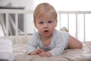 Adorable little baby lying in comfortable crib