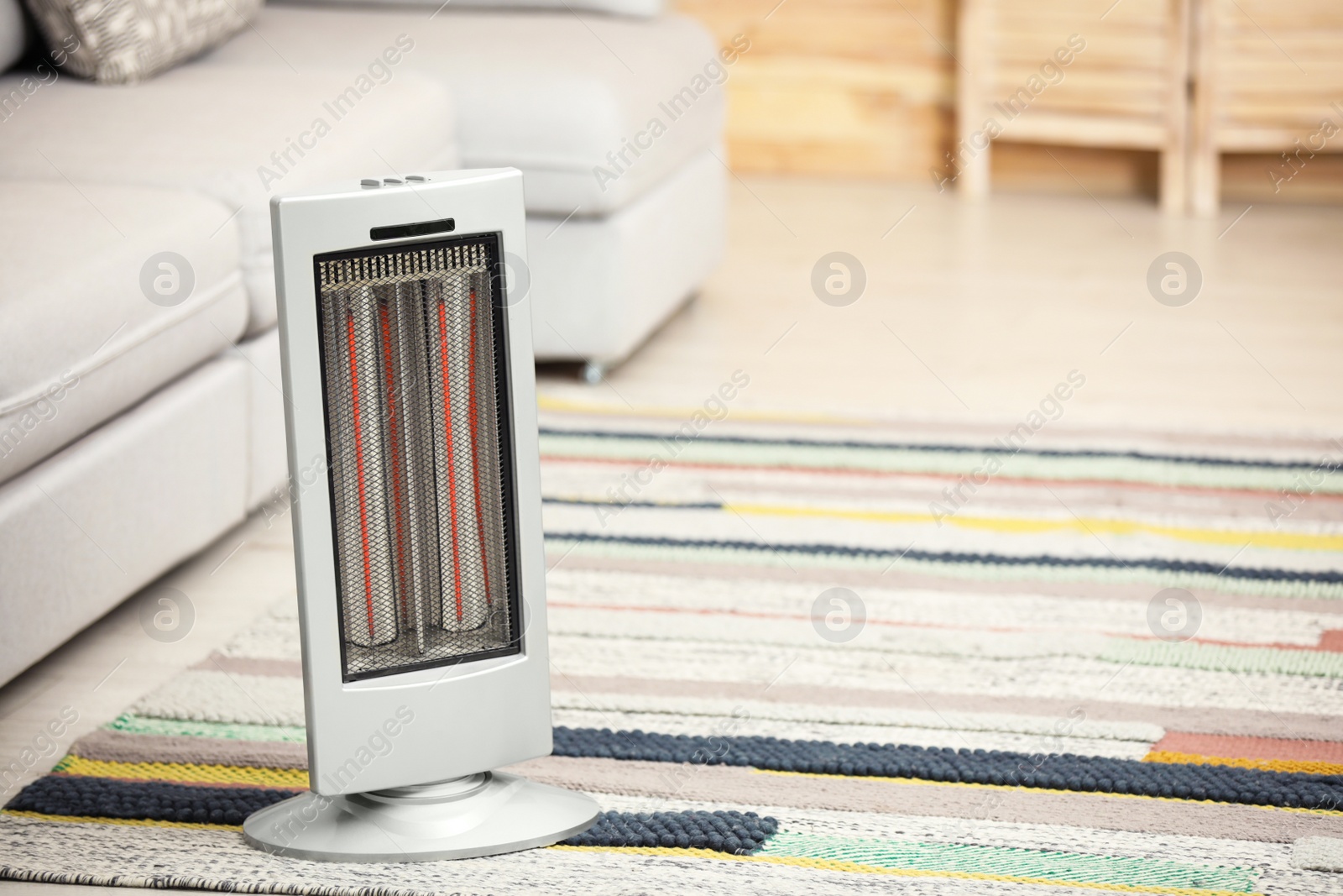 Photo of Modern electric infrared heater on floor at home. Space for text