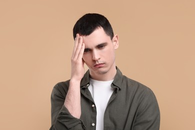 Portrait of sad man on beige background