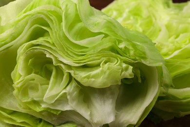 Photo of Halves of fresh green iceberg lettuce head on table, closeup