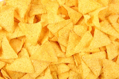 Photo of Tasty Mexican nachos chips as background, top view