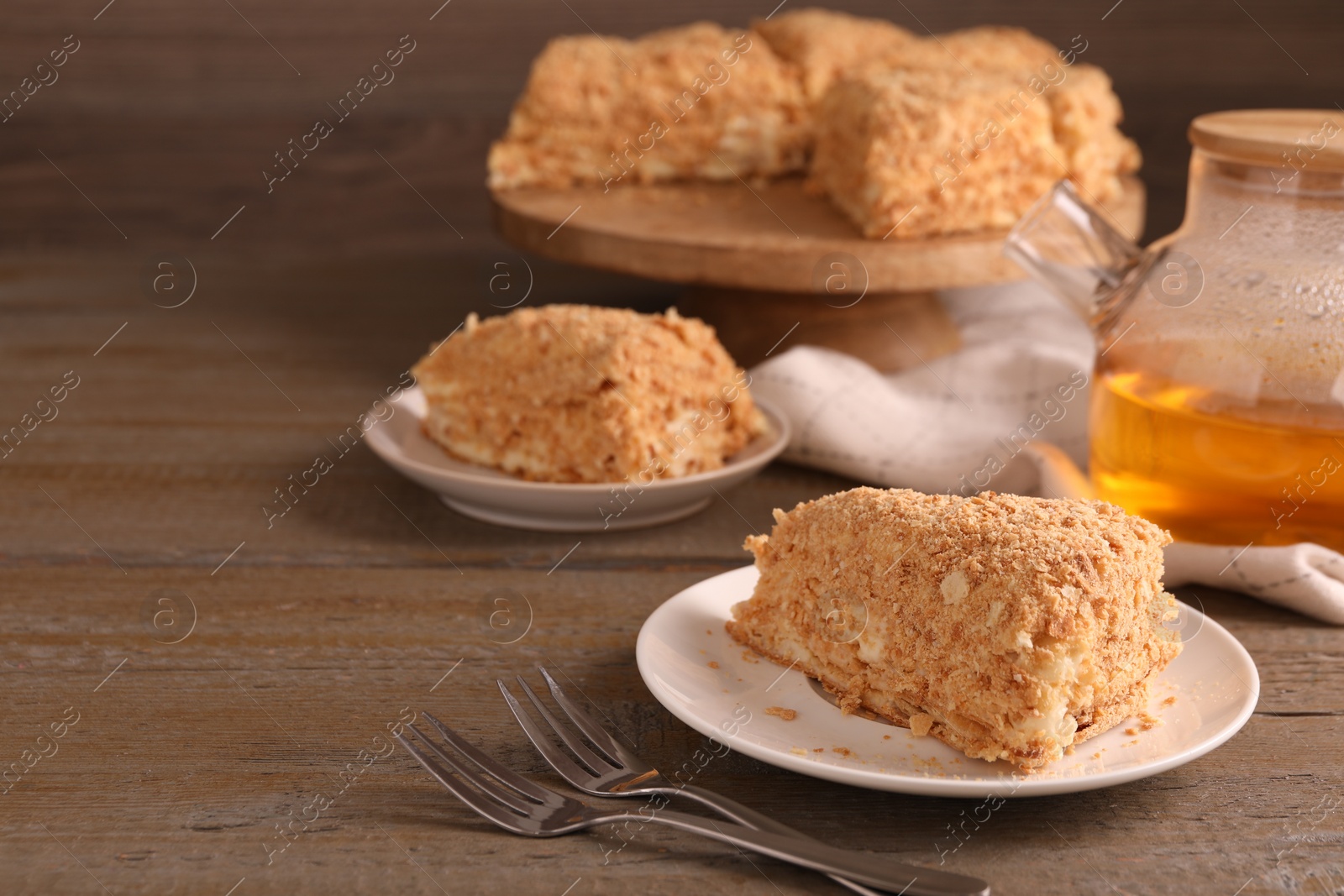 Photo of Delicious Napoleon cake served on wooden table, closeup. Space for text