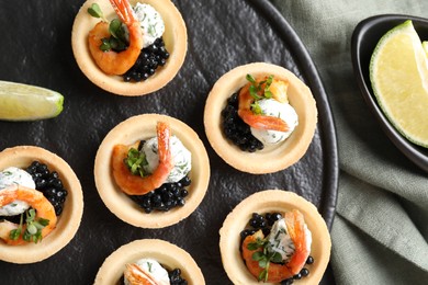 Delicious canapes with shrimps and black caviar on table, top view