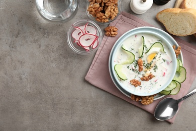 Delicious cold summer soup on grey table, flat lay. Space for text