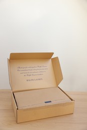 Photo of Leiden, Netherlands - December 6, 2023: Open box with Ralph Lauren garment on wooden table