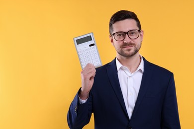 Happy accountant with calculator on yellow background. Space for text