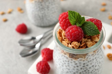 Delicious chia pudding with raspberries and granola in jar, closeup. Space for text