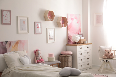 Photo of Modern teenager's room interior with comfortable bed and beautiful pictures