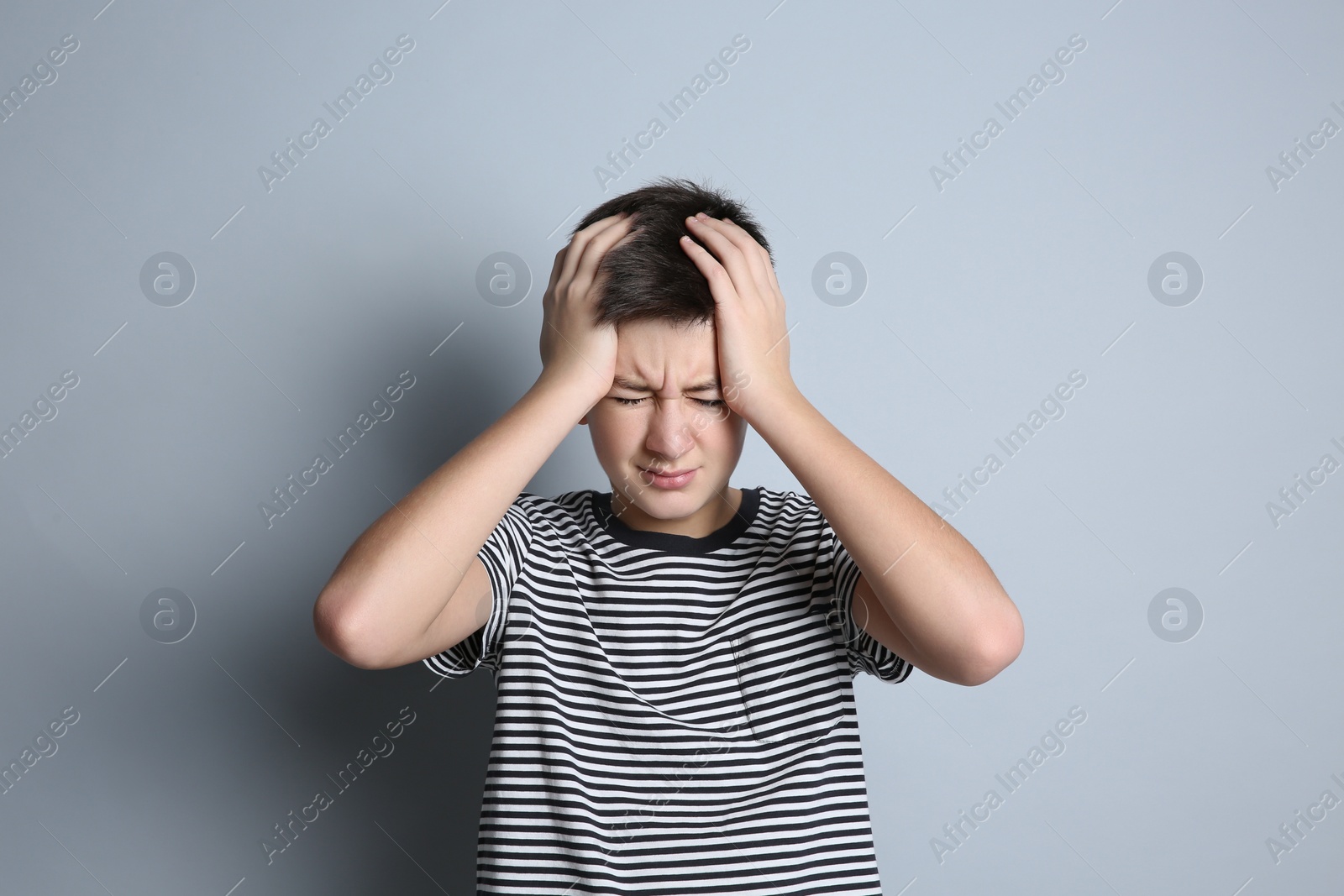 Photo of Portrait of emotional teenage boy on grey background