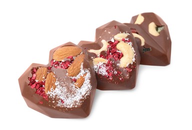 Tasty chocolate heart shaped candies with nuts on white background