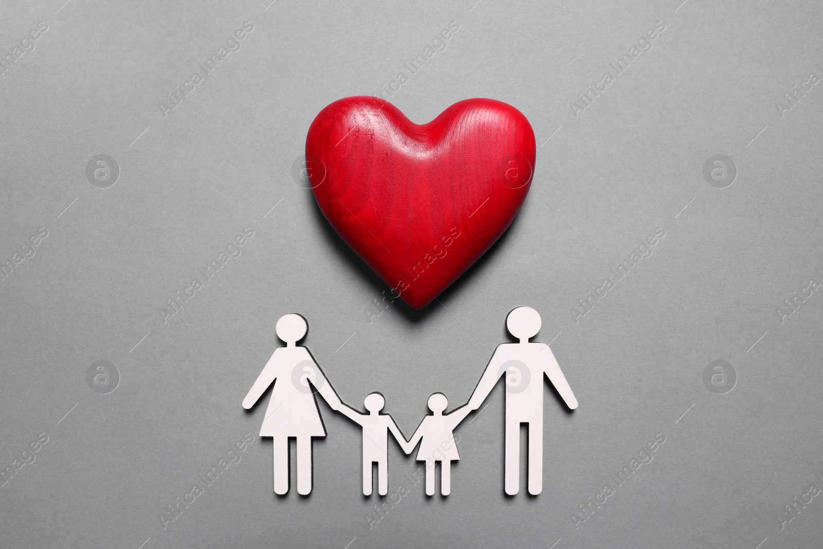 Photo of Figures of family under heart on lilac background, top view. Insurance concept