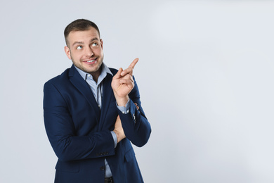 Portrait of happy young businessman on light background. Space for text