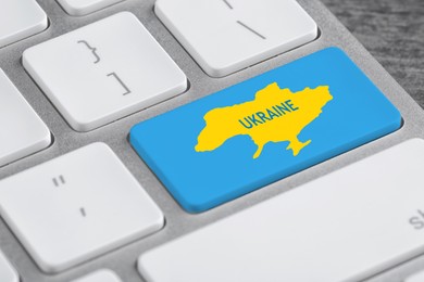 Button with map of Ukraine in colors of national flag on keyboard, closeup view