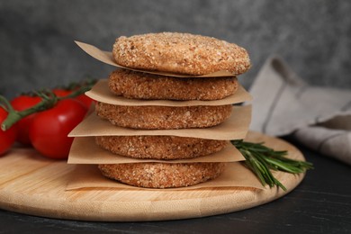 Photo of Raw vegan cutlets with breadcrumbs on black table, closeup