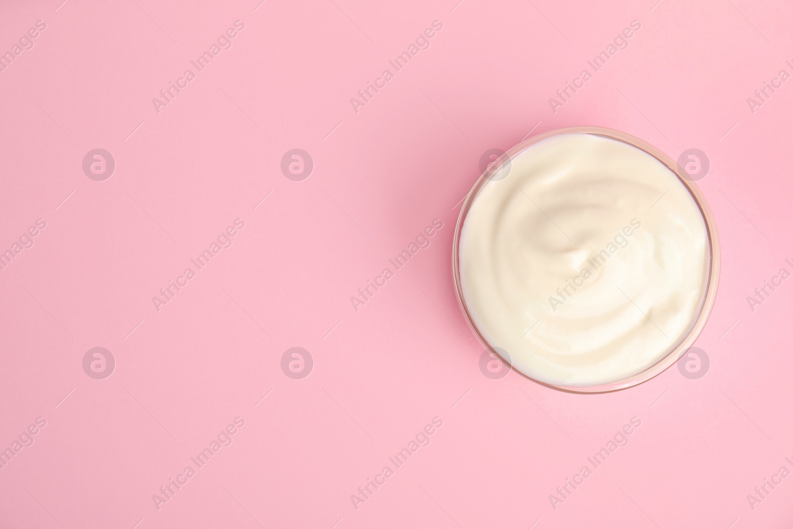 Photo of Tasty organic yogurt on pink background, top view. Space for text