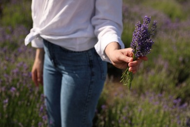 Young woman with lavender bouquet in field on summer day, closeup
