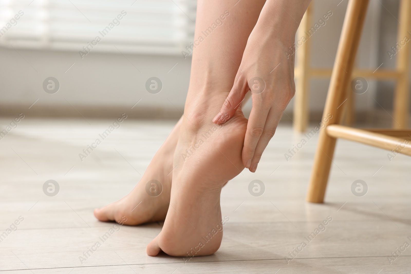 Photo of Closeup view of woman`s groomed feet after care procedure on floor