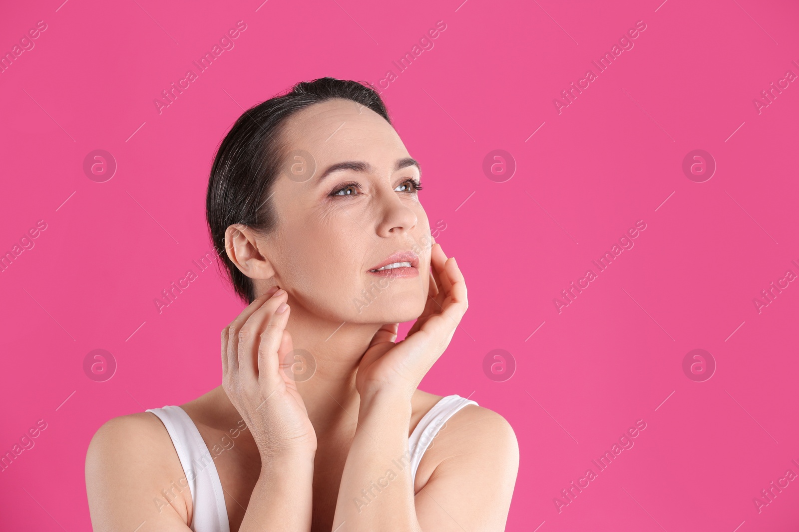 Photo of Portrait of beautiful mature woman on pink background. Space for text