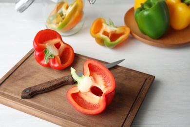 Photo of Wooden board with cut paprika pepper on table