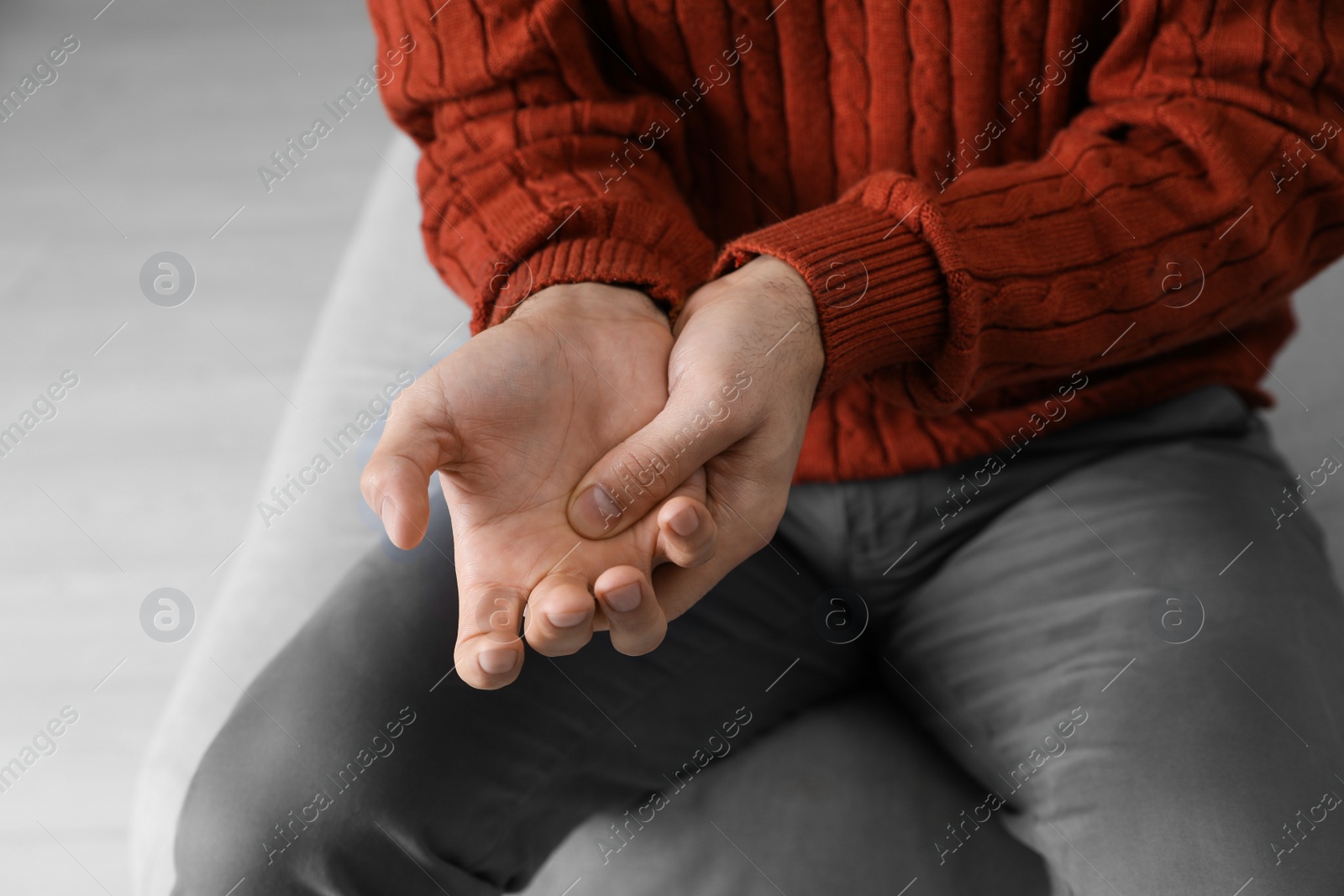 Photo of Man suffering from trigger finger indoors, closeup