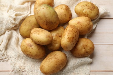 Photo of Raw fresh potatoes on light wooden table, top view