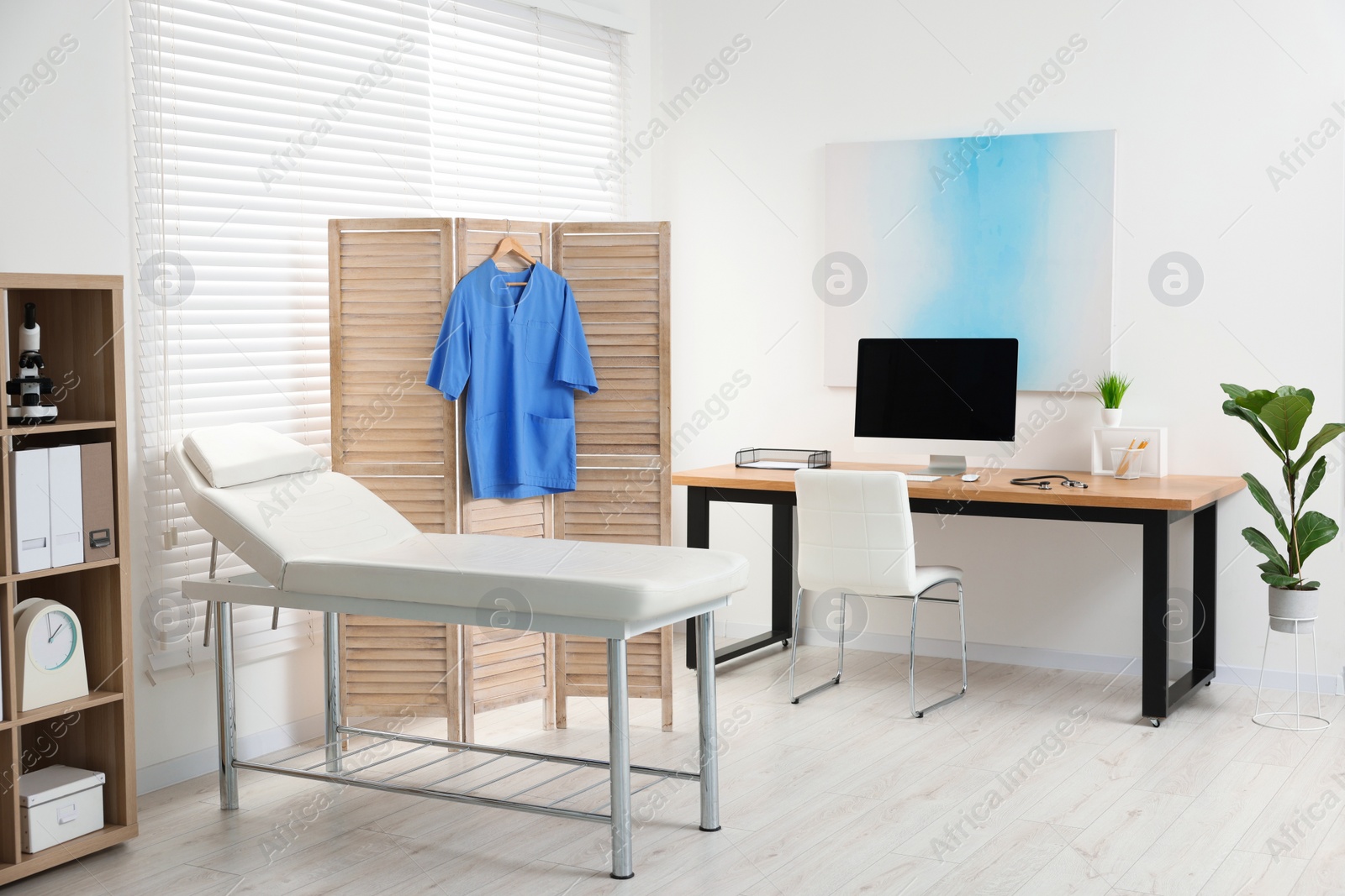 Photo of Modern medical office with doctor's workplace and examination table in clinic