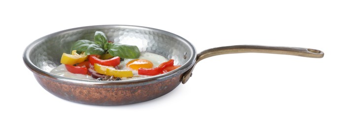 Tasty fried eggs with vegetables in pan isolated on white