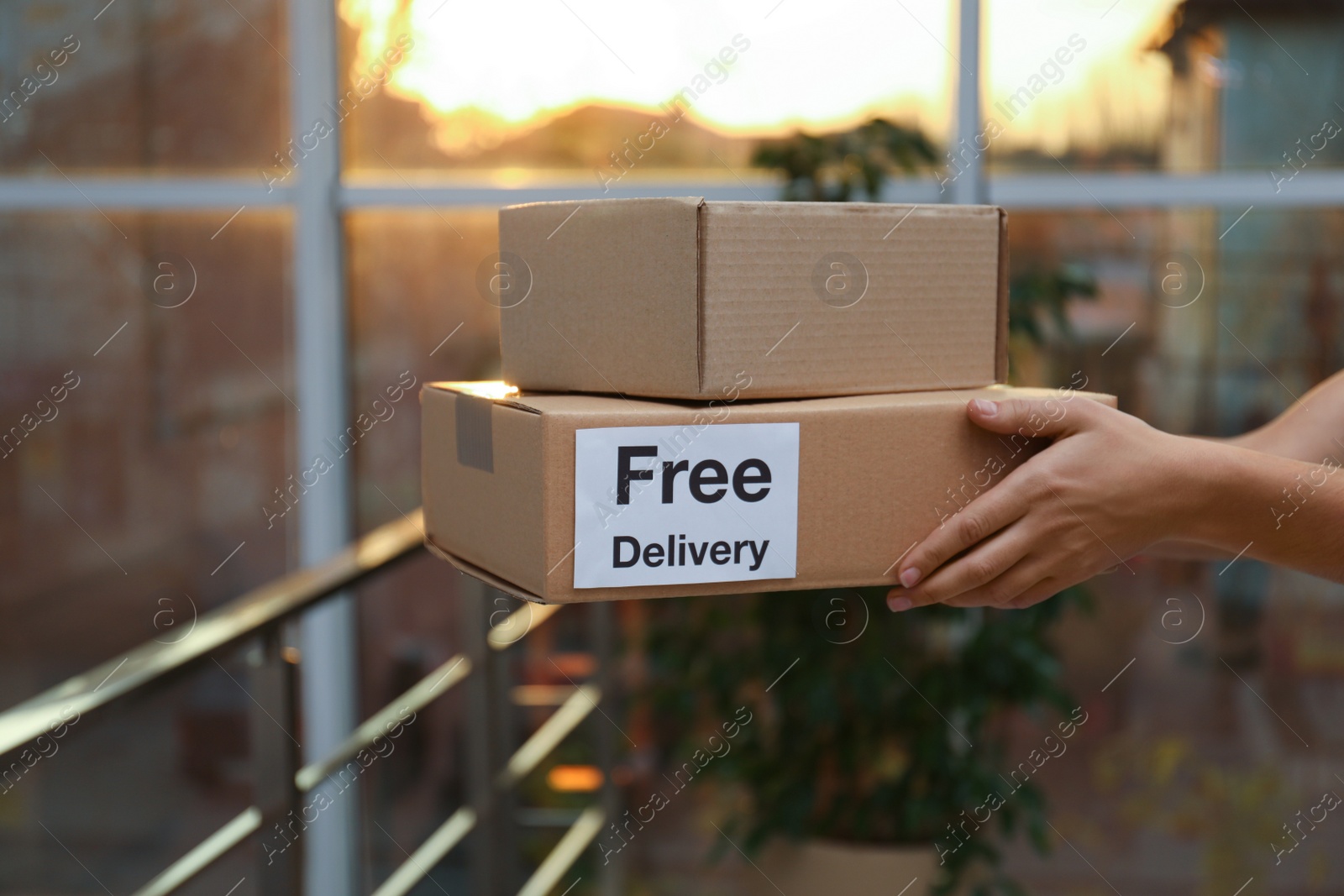 Photo of Woman holding parcels indoors, closeup. Courier service