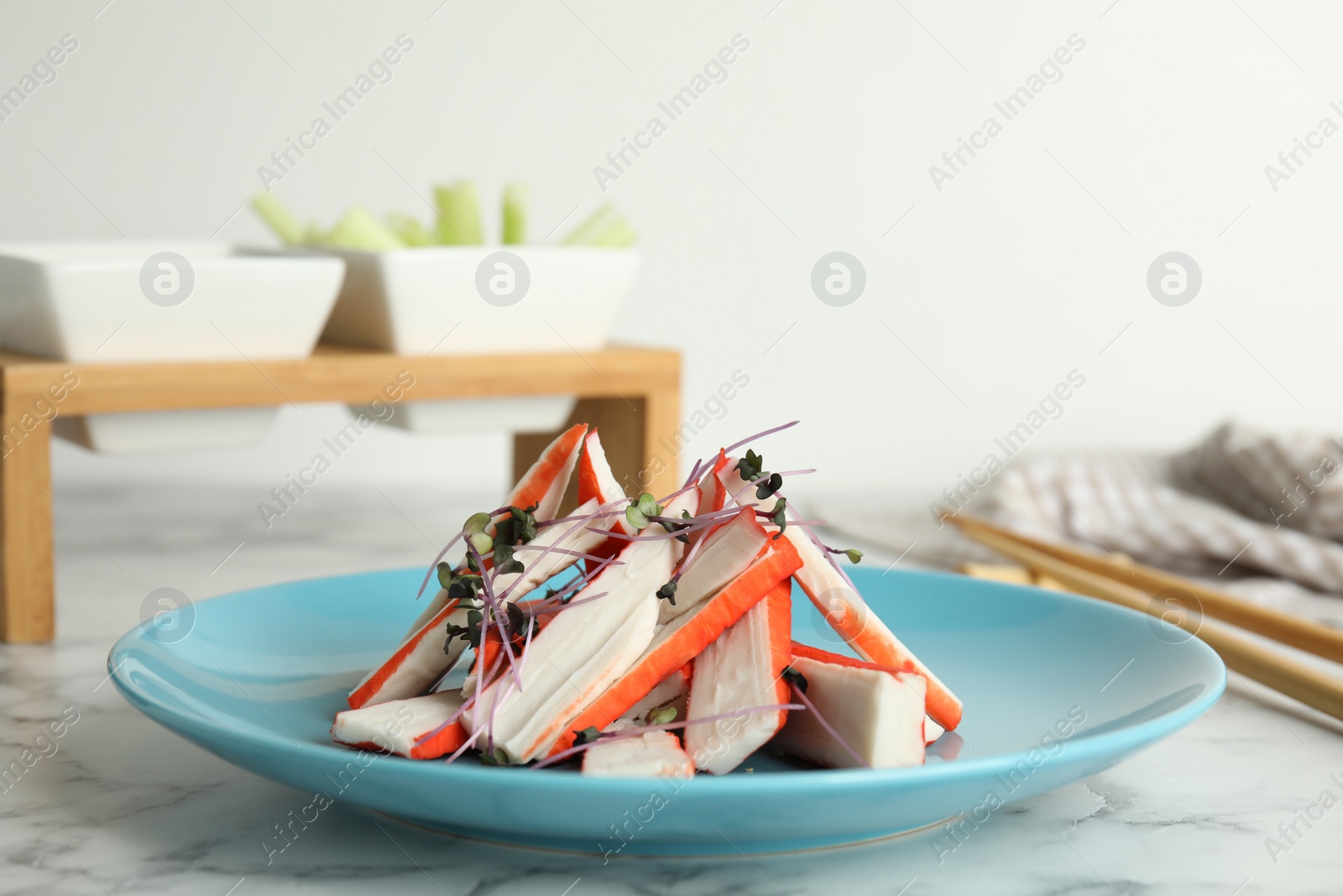 Photo of Fresh cut crab sticks served on marble table