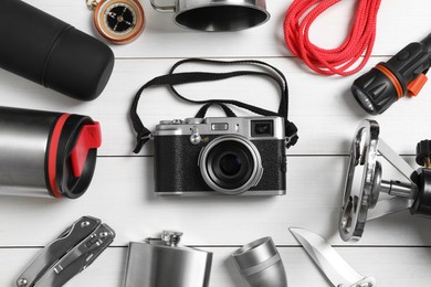 Photo of Set of traveler's equipment on white wooden table, flat lay