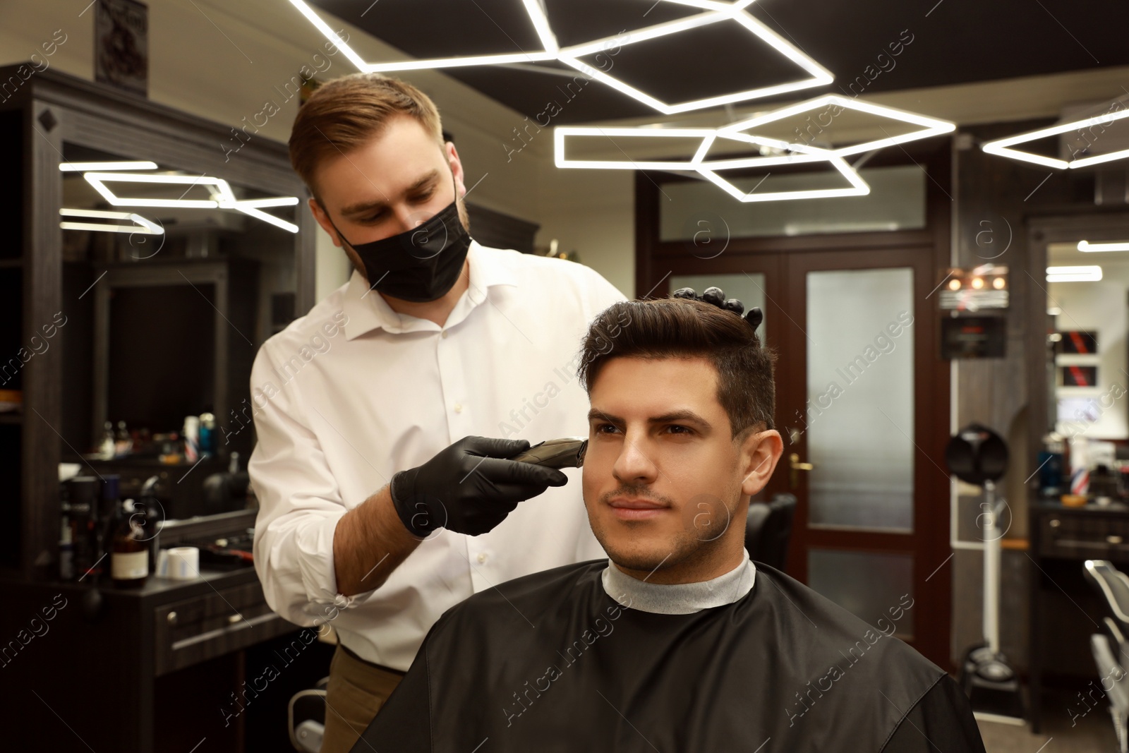 Photo of Professional hairdresser making stylish haircut in salon