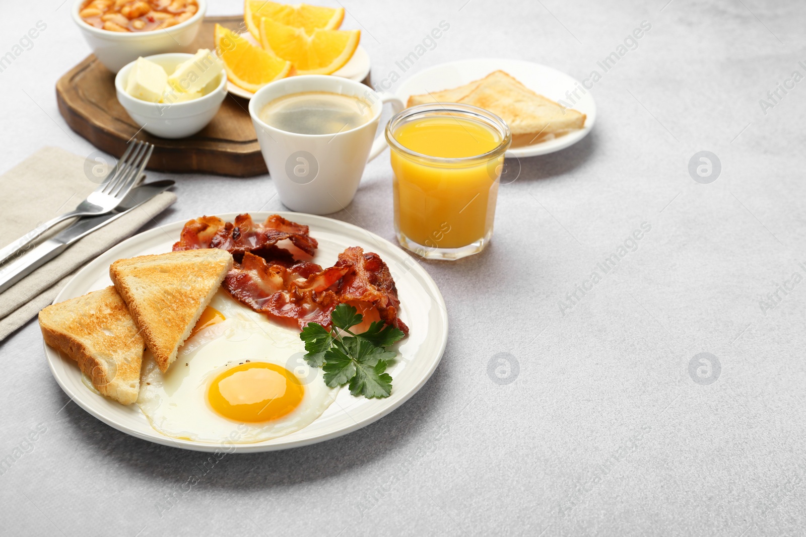 Photo of Delicious breakfast with sunny side up egg served on light table. Space for text