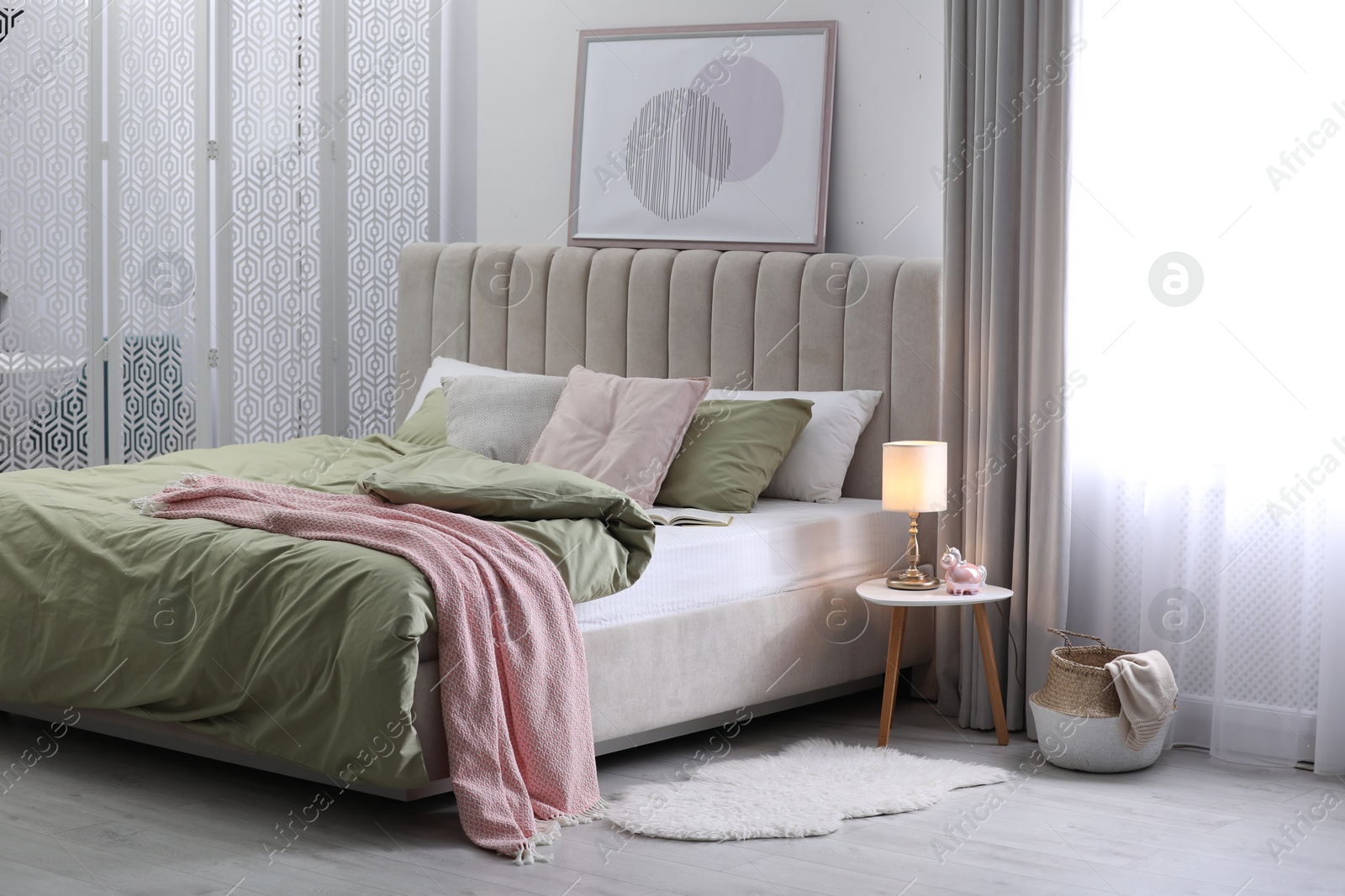 Photo of Comfortable bed with new pistachio linens in modern room interior