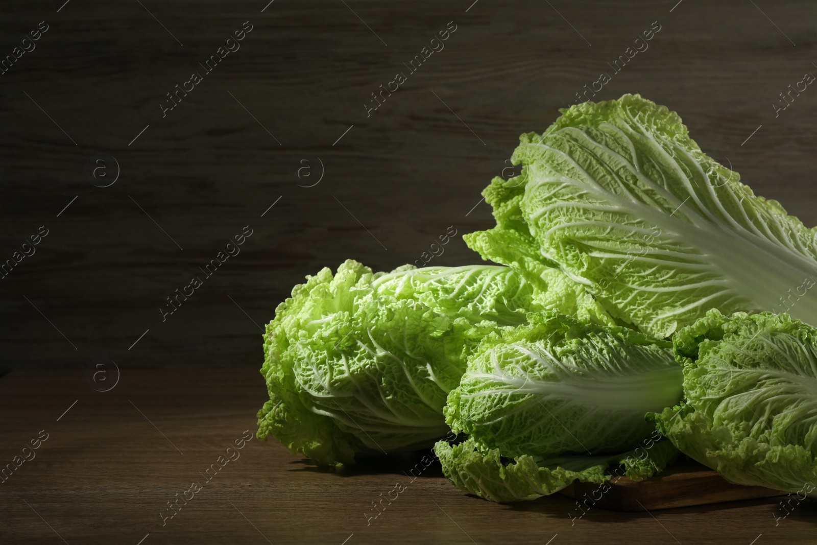 Photo of Fresh ripe Chinese cabbages on wooden table