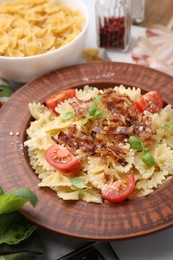 Tasty pasta with bacon, tomatoes and basil on table, closeup