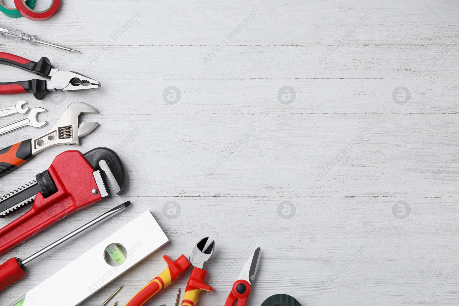 Photo of Flat lay composition with different construction tools on white wooden background. Space for text